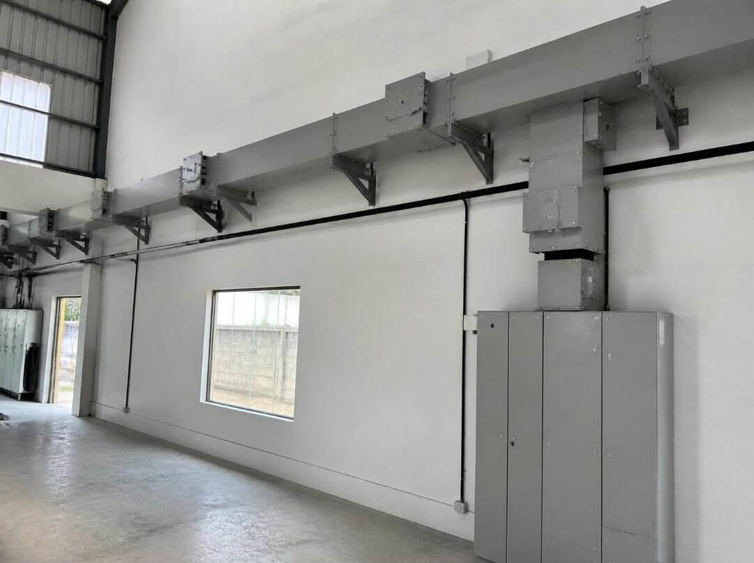 Busbar trunking (bus duct) run on wall brackets feeding an electrical panel