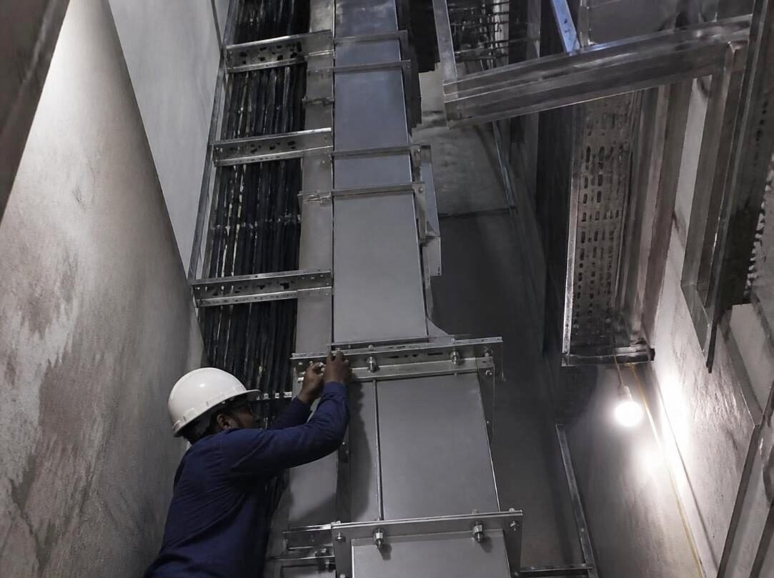 Technician fixing a vertical bus duct joint in a building riser